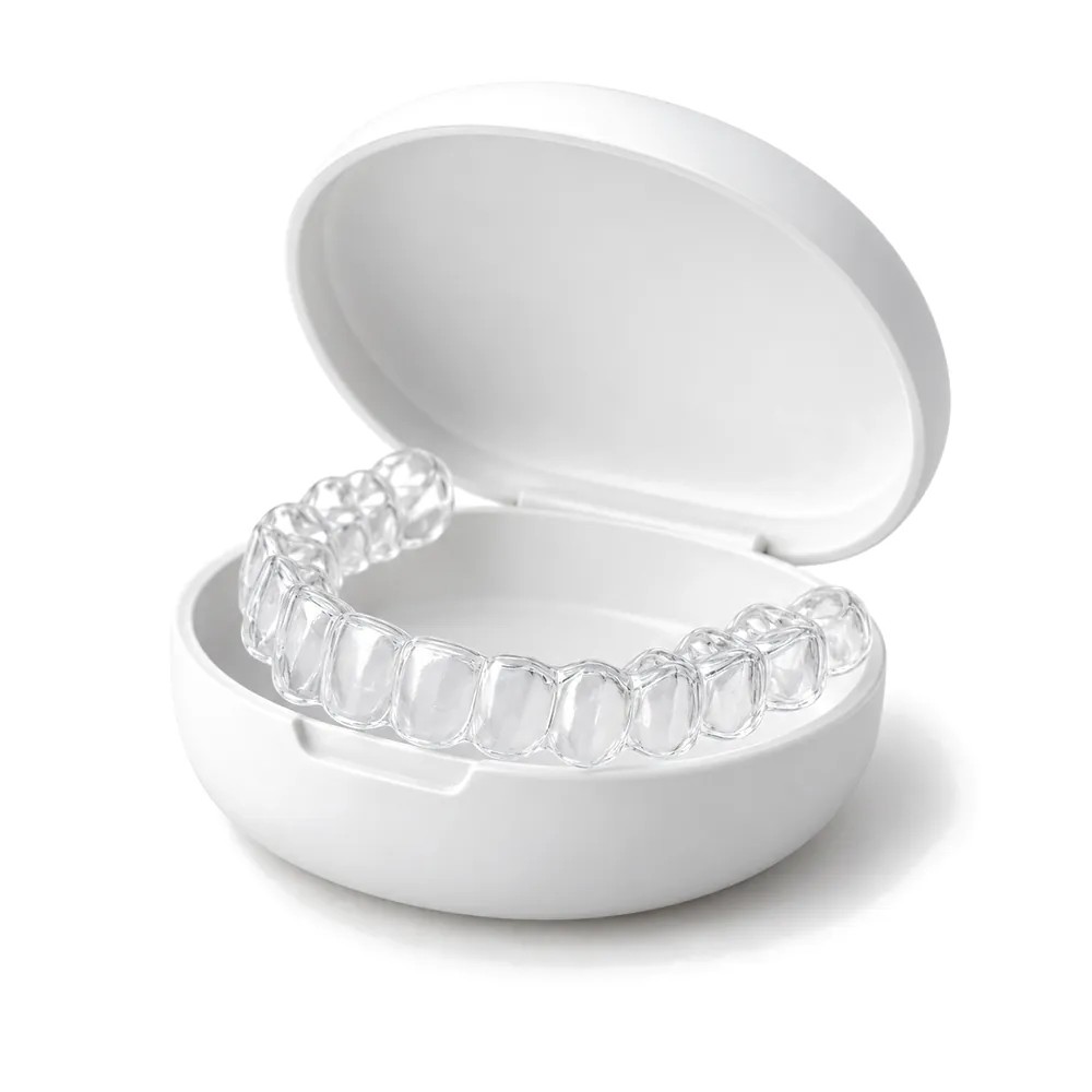 A clear aligner resting in its open case